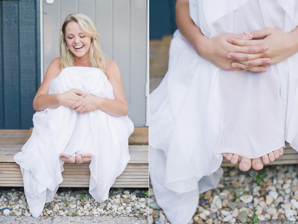 Photo Braut sitzt auf der Verandatreppe, mit angezogenen Beinen.